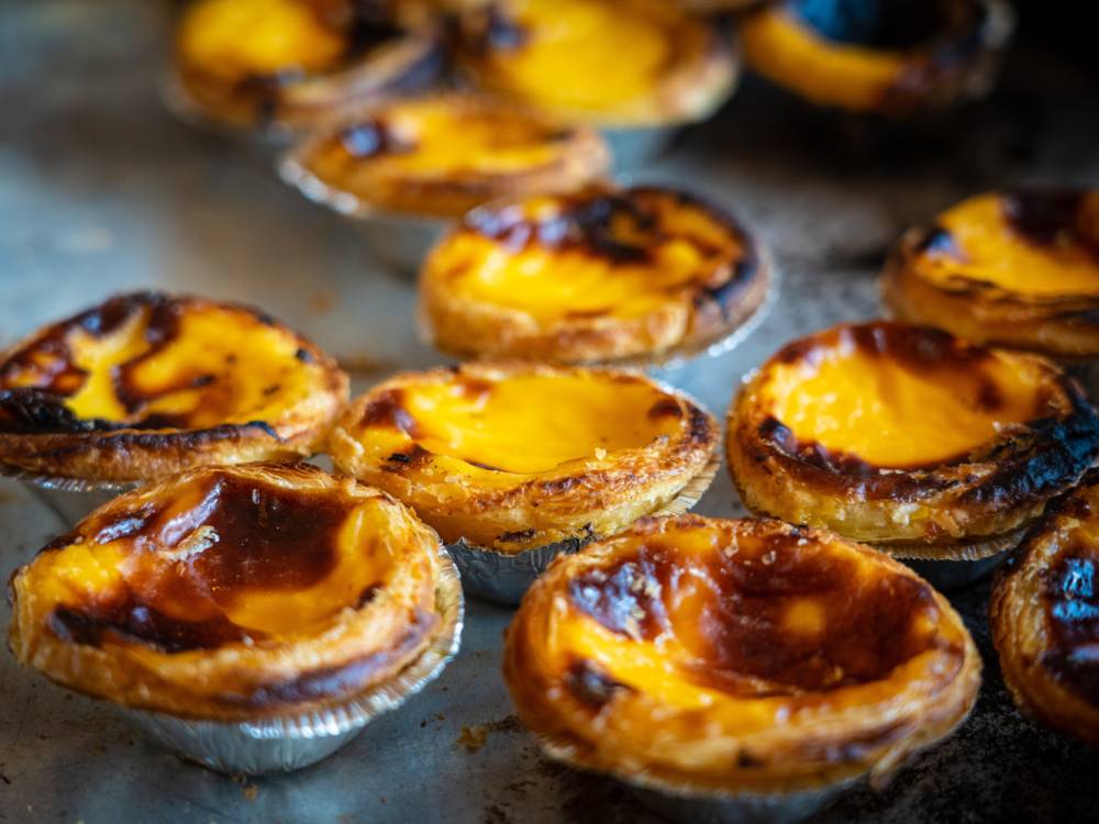 Die Pasteis de Nata sind in einem portugiesischen Café ein Muss / ©Unsplash/Nick Fewings