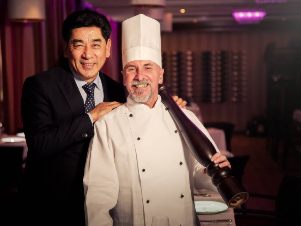 Grand Elysée-Hoteldirektor Tashi Takang (l.) und sein Kollege Wilhelm Sagas freuen sich auf die zweite Eventreihe von „Le Petit Chef“ / ©Moritz Krebs