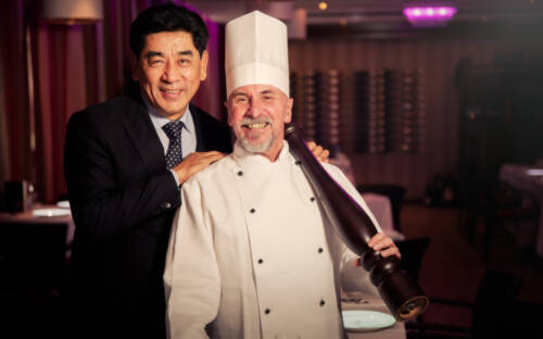 Grand Elysée-Hoteldirektor Tashi Takang (l.) und sein Kollege Wilhelm Sagas freuen sich auf die zweite Eventreihe von „Le Petit Chef“ / ©Moritz Krebs